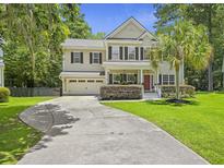 Charming two-story home with a well-manicured lawn, long driveway, attached garage and a delightful red front door at 1228 Walleye Cor, Charleston, SC 29414