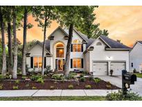 Charming two-story home with a well-manicured lawn, flower beds, and a two-car garage at 1311 Royal Links Dr, Mount Pleasant, SC 29466