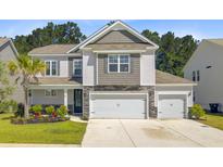 Charming two-story home with a landscaped yard and a three car attached garage at 142 Airy Dr, Summerville, SC 29486