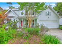 Charming two-story home featuring a bright red front door, mature landscaping, and an attached two car garage at 1972 Gray Battery Ct, Mount Pleasant, SC 29464