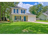 Charming two-story home with a well-manicured lawn, inviting front porch, and blue shutters at 2538 Wayne Scott Ct, Charleston, SC 29414