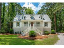 Charming two-story home with a welcoming front porch, gray shutters, and a well-manicured lawn at 338 Mcclellan Ave, McClellanville, SC 29458