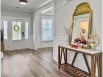 Bright foyer features white trim, a wood-look floor, console table and decorative mirror at 360 Parish Farms Dr, Summerville, SC 29486