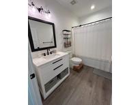 Modern bathroom featuring a white vanity with black accents and a shower with a white curtain at 400 Bucksley Ln # 301, Charleston, SC 29492
