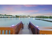 Waterfront view from dock with fishing poles in a beautiful community with a fountain in the lake at 4765 Arco Ln, North Charleston, SC 29418