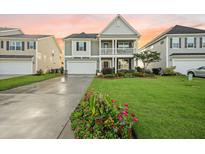 Charming two-story home featuring a welcoming front porch, landscaped yard, and attached two-car garage at 529 Dunswell Dr, Summerville, SC 29486
