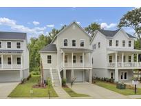 Charming two-story home with a quaint front porch, driveway, and manicured landscaping at 619 Du Bois Dr, Johns Island, SC 29455