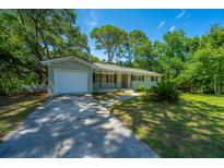 Charming single-story home featuring a well-maintained yard, attached garage, and inviting curb appeal at 734 Waterloo St, Charleston, SC 29412