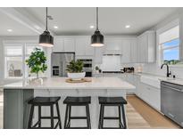 Bright kitchen featuring a large island with pendant lighting and modern appliances at 753 Blue Iris Way, Summerville, SC 29486