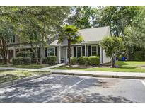 Charming home with a well-maintained lawn, mature trees, and dedicated parking spots at 8059 Shadow Oak Dr, North Charleston, SC 29406