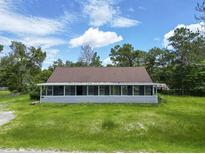 Classic single-story home with a welcoming porch and a lush green lawn under a bright sky at 93 Knights Ave, Walterboro, SC 29488