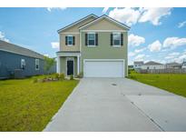 Charming two-story home featuring a manicured lawn, two-car garage, and inviting curb appeal at 1032 Peridote Way, Ladson, SC 29456