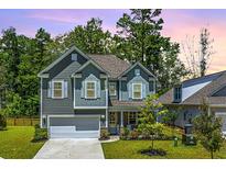 Charming two-story home with manicured lawn and attached two-car garage at 104 Limpkin Ln, Summerville, SC 29483