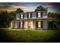 Charming two-story home featuring a covered front porch, dark shutters, and a lush green lawn at 107 Sugarpine Pl, Summerville, SC 29486