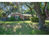 Charming brick home with lush landscaping and mature trees offering shade at 1126 Brigantine Dr, Charleston, SC 29412