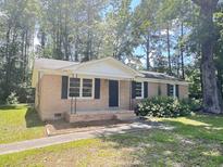 Charming single-story brick home featuring classic design, black shutters, and a well-manicured front yard at 114 Madison St, Walterboro, SC 29488