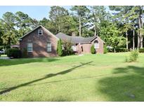 Charming brick home with manicured lawn and mature trees, offering classic curb appeal and a welcoming atmosphere at 1457 Green Pond Hwy, Walterboro, SC 29488