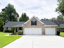 Well-maintained brick house with a large driveway and manicured landscaping, three car garage at 1804 Bass Rd, Moncks Corner, SC 29461