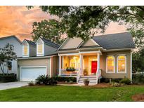 Charming home featuring a welcoming front porch, a bright red front door, and a lush, landscaped yard at 1809 Two Cedar Way, Mount Pleasant, SC 29466