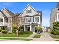 Charming two-story home featuring gray siding, black shutters, and a well-maintained front yard at 1821 Towne St, Johns Island, SC 29455