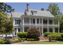 Two-story home featuring a charming wrap-around porch, lush landscaping, and a beautiful fountain at 208 Sumter Ave, Summerville, SC 29483