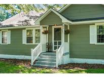 Charming home featuring a welcoming front entrance with hanging flower baskets and a cozy chair on the porch at 286 Mallard Lake Rd, Dorchester, SC 29437