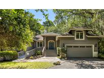 Charming home featuring a lovely gray exterior, welcoming stairs, mature trees, and an attached garage at 2938 Old Drake Dr, Seabrook Island, SC 29455