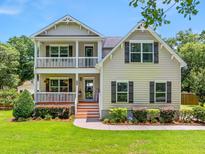 Charming two-story home with a inviting front porch and manicured lawn at 309 Pinopolis Park Dr, Moncks Corner, SC 29461
