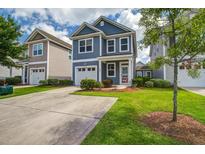 Charming two-story home featuring a well-manicured lawn, driveway, and attached garage at 3903 Poplar Grove Pl, Summerville, SC 29483