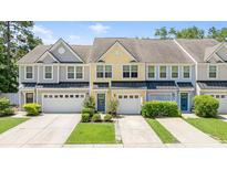 Charming townhomes featuring colorful facades, attached garages, and well-manicured landscaping at 412 Grand Palm Ln, Summerville, SC 29485