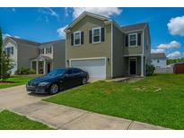 Charming two-story home with a manicured lawn and a driveway leading to an attached garage at 431 Buckhannon Ln, Moncks Corner, SC 29461