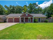 Charming single-story home with a well-maintained lawn, attached garage, and beautiful landscaping at 439 Temple Rd, Ladson, SC 29456