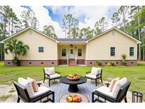 Charming yellow home with a well-maintained lawn and inviting outdoor seating area at 480 Longleaf Dr, Walterboro, SC 29488