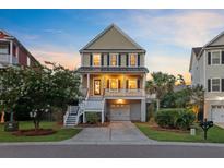 Charming two-story home featuring a welcoming porch, well-maintained landscaping, and convenient ground-level garage at 492 Sanders Farm Ln, Wando, SC 29492