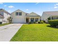 Charming yellow two-story home with a well-manicured lawn, attached garage, and welcoming front porch at 504 Dolphin Dr, Summerville, SC 29485