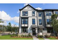 Charming two-story townhome with black trim, a covered entry, and professional landscaping at 560 Scholar Way, Summerville, SC 29486