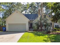 Charming one-story home featuring a two-car garage, manicured lawn, and lush landscaping at 642 Bridlewood Ln, Mount Pleasant, SC 29464