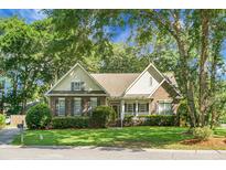 Charming home featuring a brick facade, well-manicured lawn, and mature trees, creating an inviting curb appeal at 652 Spinner Cir, Mount Pleasant, SC 29464