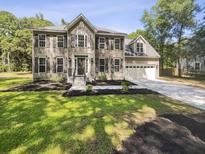 Charming two-story home with landscaped front yard, concrete driveway, and attached two-car garage at 702 Spark St, Mount Pleasant, SC 29464