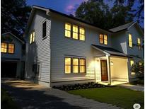 Charming two-story home with a well-manicured lawn and inviting front porch at dusk at 758 Mccants Dr, Mount Pleasant, SC 29464
