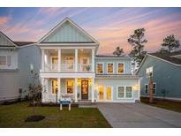 Stunning two-story home with a welcoming front porch and balcony, featuring light blue siding and white trim at 766 Maynard Ln, Summerville, SC 29486