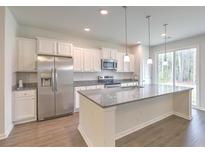 Modern kitchen with stainless steel appliances, granite countertops, and a large island at 9430 Sweep Dr, Summerville, SC 29485