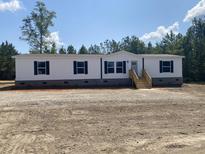 Charming manufactured home featuring black shutters and wooden front porch at 1010 Universal Cir, Saint Stephen, SC 29479
