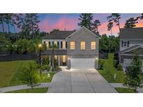 Charming two-story brick home with well-maintained landscaping, two-car garage, and a beautiful twilight sky at 106 Claremont Ct, Summerville, SC 29486