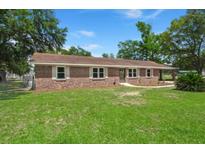 Charming brick ranch-style home featuring a well-manicured lawn and mature trees offering plenty of shade at 122 Lawrence Rd, Moncks Corner, SC 29461