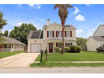 Charming two-story home with vinyl siding, red shutters, front yard landscaping, and solar panels at 136 Blue Jasmine Ln, Summerville, SC 29483