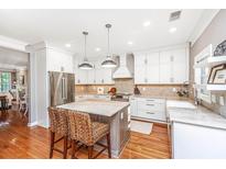Bright eat-in kitchen boasts stainless appliances, an island, and ample white cabinetry at 136 Fair Sailing Rd, Mount Pleasant, SC 29466