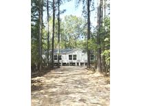 Charming single-story home with white siding and dark trim surrounded by tall trees at 144 Craft Ln, Round O, SC 29474