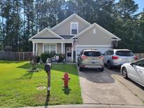 Charming home featuring a manicured lawn, a fire hydrant, and a cozy front porch at 207 Short Woods Ct, Summerville, SC 29486