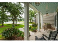 Inviting front porch with peaceful view of lake, hammock, and mature trees at 233 Camber Rd, Huger, SC 29450